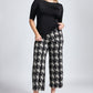 Front view of woman wearing a half sleeve boat neck fuller bust pullover with back scoop neck paired with wide leg cropped houndstooth pants by Miriam Baker.