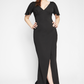 Front view of a woman wearing a fuller bust stretch jersey black evening gown with a plunging neckline designed by Miriam Baker.