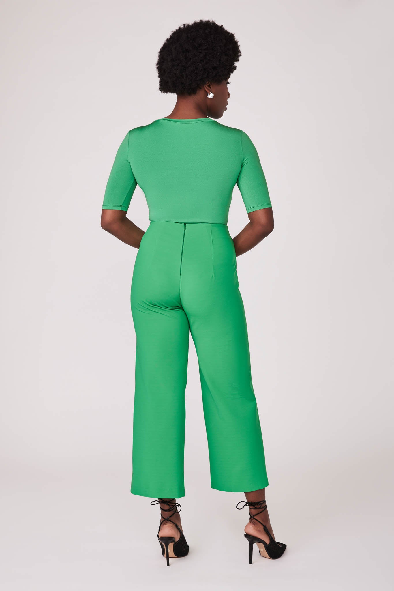 Back view of a woman wearing a half sleeve crew neck fuller bust T-shirt paired with matching wide leg cropped pants in vibrant kiwi green by Miriam Baker.