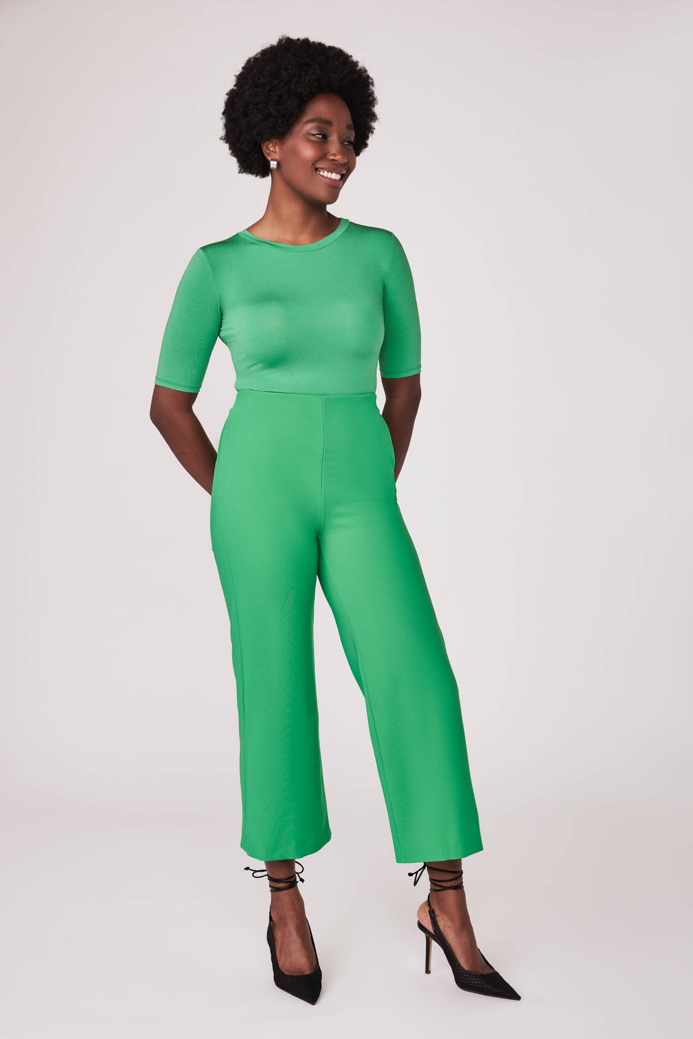 Front view of a woman wearing a half sleeve crew neck fuller bust T-shirt paired with matching wide leg cropped pants in vibrant kiwi green by Miriam Baker.