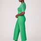 Side view of a woman wearing a half sleeve crew neck fuller bust T-shirt paired with matching wide leg cropped pants in vibrant kiwi green by Miriam Baker.