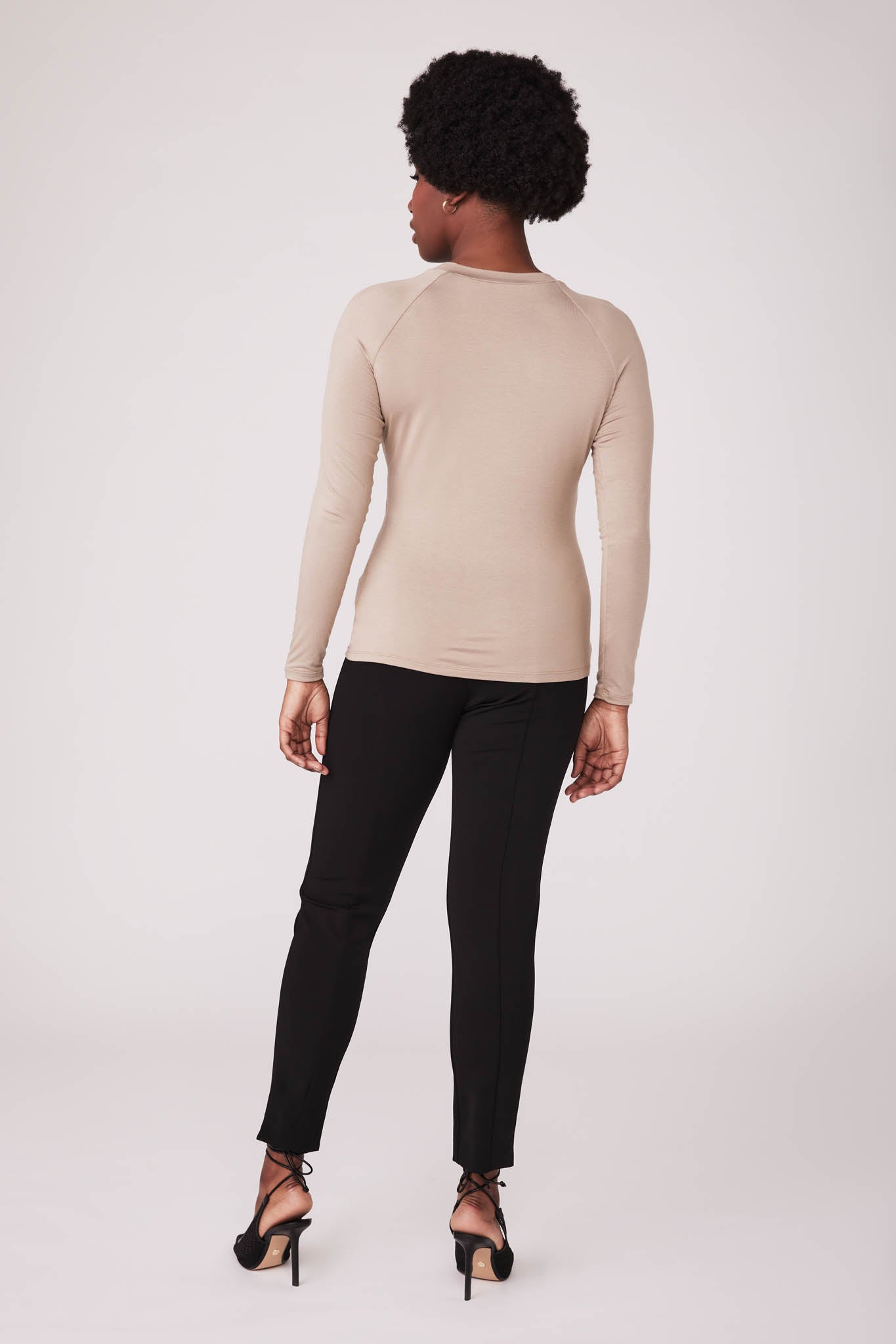 Back view of a woman wearing a beige bamboo crew neck raglan sleeve fuller bust pullover designed by Miriam Baker.