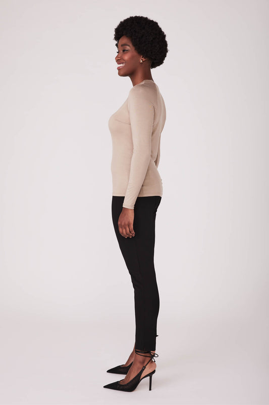Side view of a woman wearing a beige bamboo crew neck raglan sleeve fuller bust pullover designed by Miriam Baker.