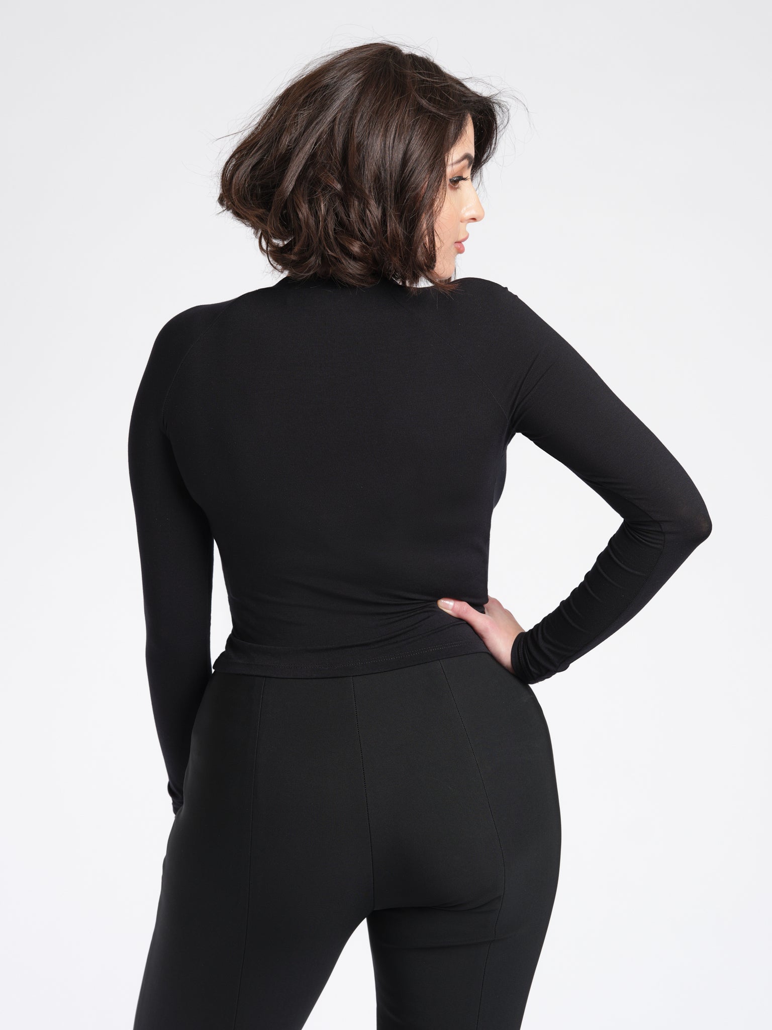 Detailed back view of a woman wearing a black bamboo crew neck raglan sleeve fuller bust pullover designed by Miriam Baker.