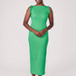 Front view of a woman wearing a green stretch viscose fuller bust midi length bodycon dress with shoulder ruffles and a back slit designed by Miriam Baker.