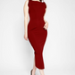 Front view of a woman wearing a red stretch viscose fuller bust midi length bodycon dress with shoulder ruffles and a back slit designed by Miriam Baker.