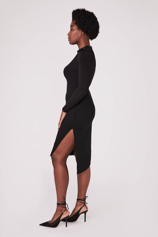 Side view of a woman wearing a high waisted black asymmetrical pencil skirt with cut out by Miriam Baker.