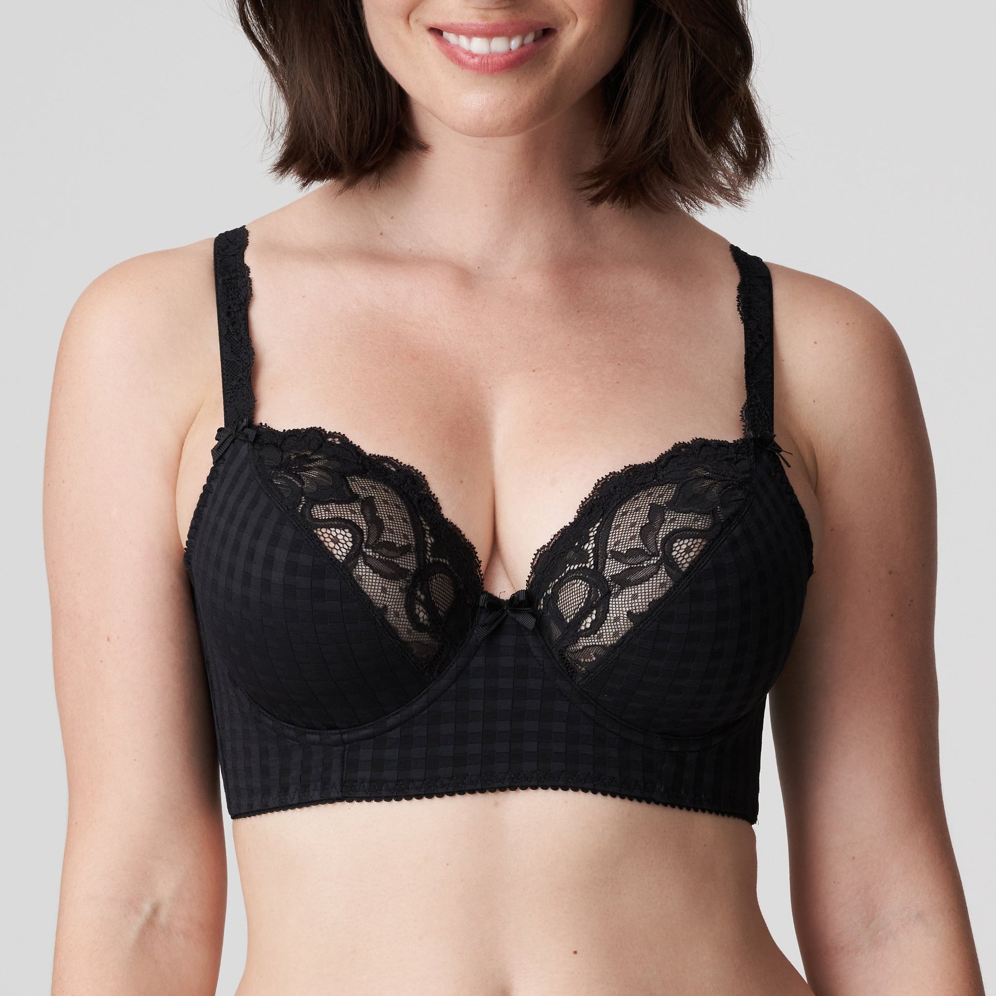 Front view of a woman wearing the Madison Longline Bra with plunging neckline in Black by PrimaDonna.