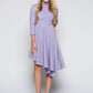 Front view of a woman wearing a asymmetric mock neck fuller bust dress with 3/4 length sleeves and side seam pockets in lilac stretch viscose fabric by Miriam Baker.
