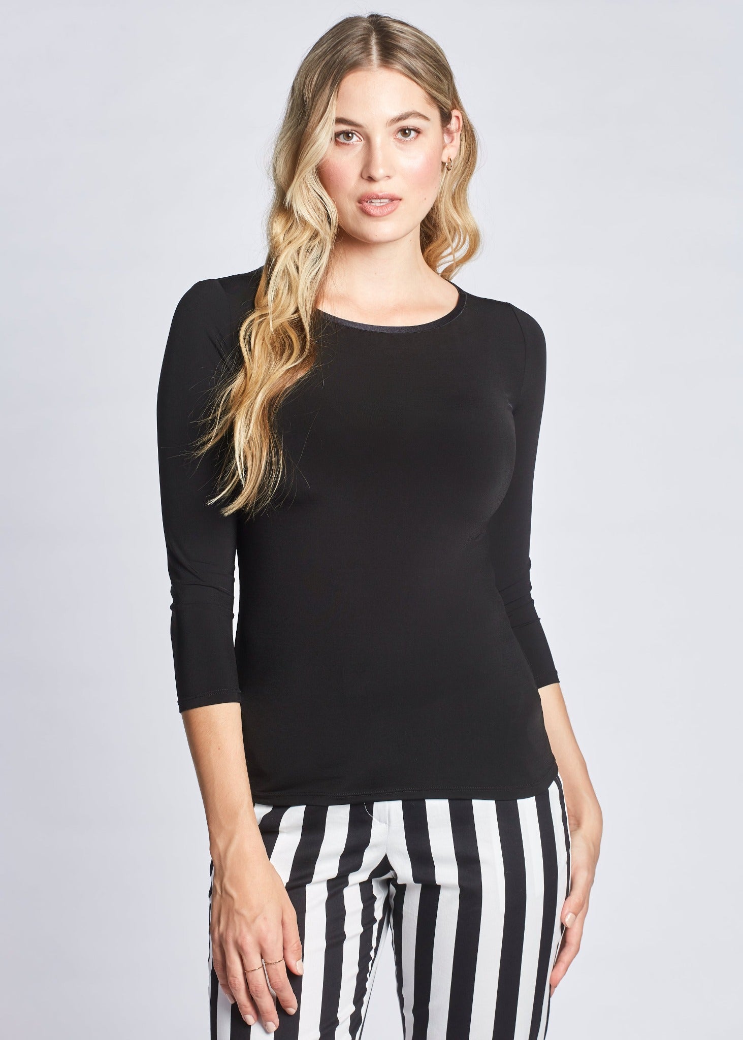 Front view of a woman wearing a black 3/4 length sleeve fuller bust viscose pullover with a jewel neckline by Miriam Baker.