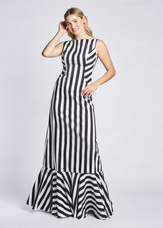 Front view of a woman wearing a black and white stripe fuller bust evening gown with princess lines and slash pockets designed by Miriam Baker.