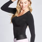 Side view of a woman wearing a black fuller bust long sleeve scoop neck pullover designed by Miriam Baker.