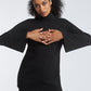 Woman wearing a black fuller bust tunic style top with flared sleeves in stretch crepe fabric designed by Miriam Baker.