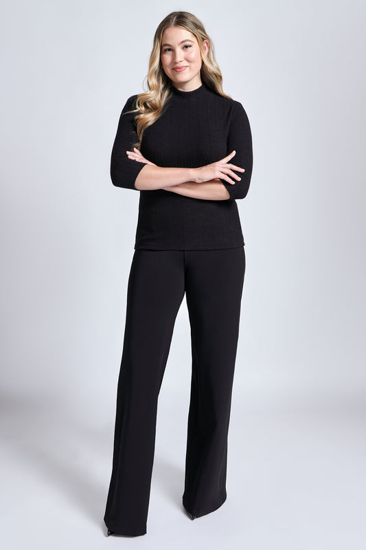 Woman wearing a black fuller bust mock neck pullover with 3/4 length sleeves designed by Miriam Baker.