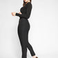 Side view of a woman wearing a pair of black stretch viscose cropped pants with an elastic waist, split hems and pockets by Miriam Baker.