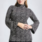 Woman wearing a daisy print fuller bust tunic style top with flared sleeves in stretch jersey fabric designed by Miriam Baker.