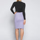 Back view of a woman wearing a knee length stretch viscose pencil skirt with side slit and back invisible zipper in lilac by Miriam Baker.