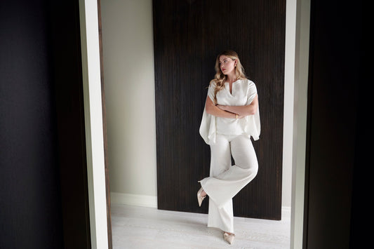 Woman wearing a fuller bust split sleeve linen blouse with bust darts paired with matching high-waisted linen trousers designed by Miriam Baker.