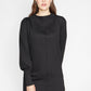 Woman wearing a long sleeve fuller bust mock neck shift dress with pockets in black stretch jersey designed by Miriam Baker.