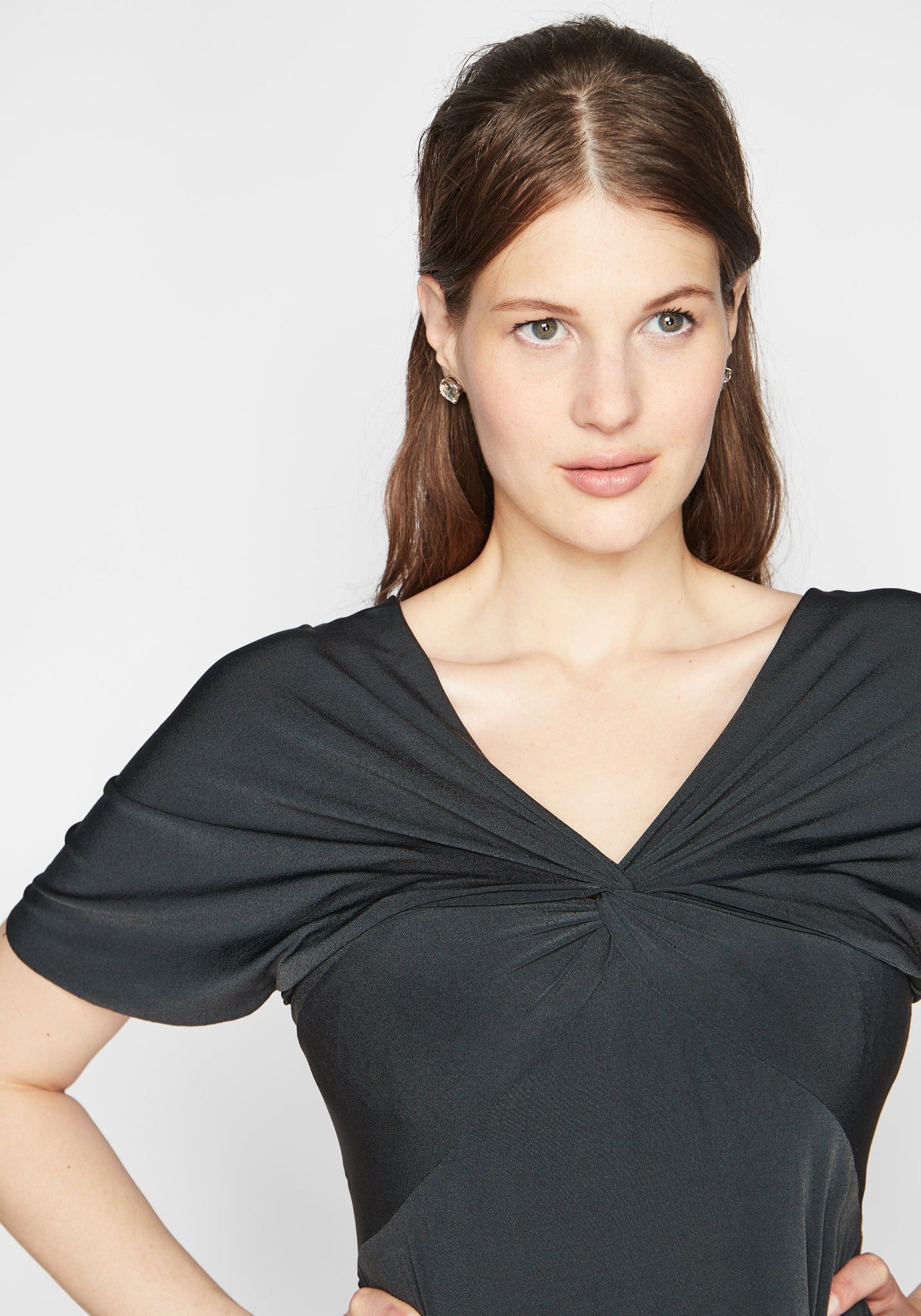 Woman wearing a fuller bust low cut v-neck top with a butterfly twist detail at the empire waist in grey stretch viscose jersey by Miriam Baker.