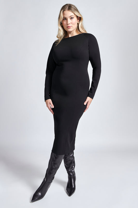 Woman wearing a black raglan sleeve fuller bust midi length stretch bodycon dress with back slit and invisible zipper by Miriam Baker. 