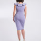 Back view of a woman wearing a stretch viscose fuller bust v-neck sheath dress with ruffles that frame the neckline in lilac designed by Miriam Baker.