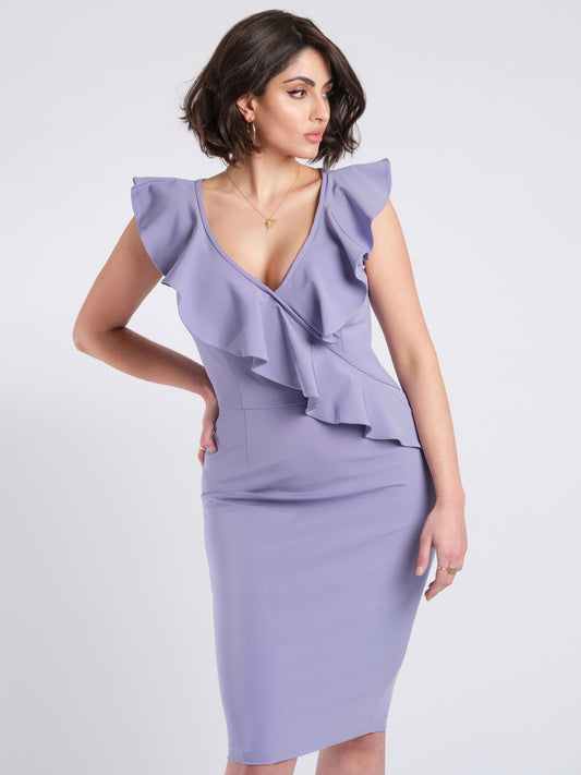 Woman wearing a stretch viscose fuller bust v-neck sheath dress with ruffles that frame the neckline designed by Miriam Baker.