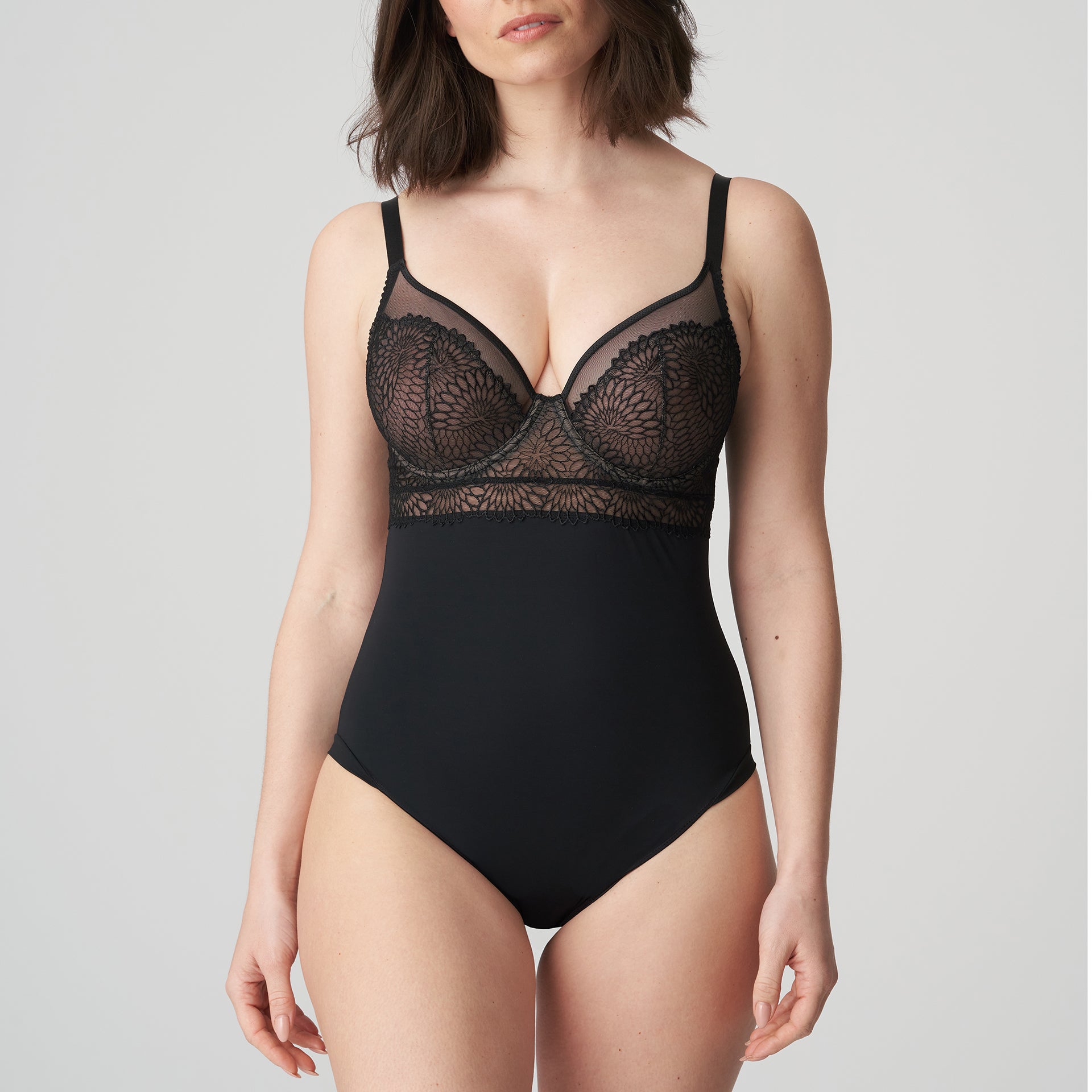 Woman wearing a black DD+ open back bodysuit with built in full support underwire bra by Primadonna.