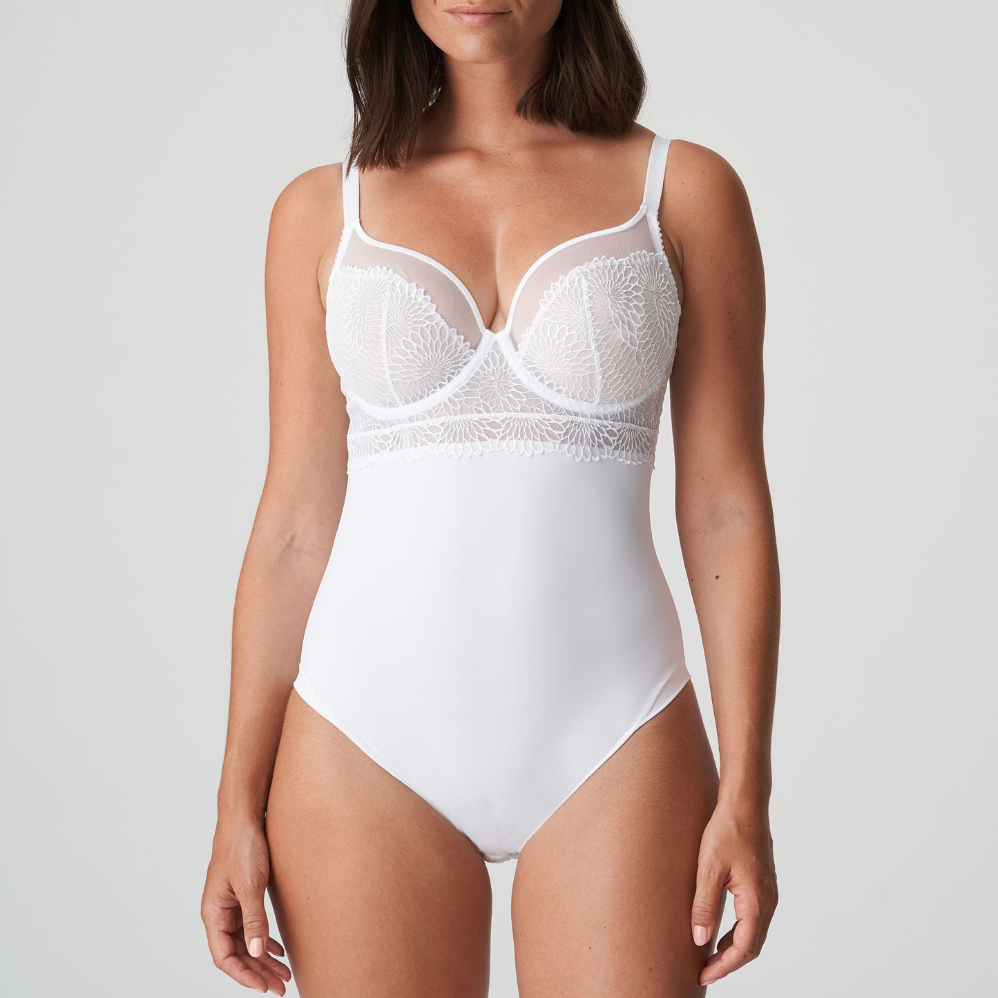 Front view of a woman wearing a DD+ open back bodysuit with built in full support underwire bra in white by Primadonna.