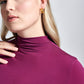 Close up detail of a woman wearing a violet stretch viscose fuller bust long sleeve mock neck pullover by Miriam Baker.
