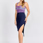 Side view of a woman wearing a navy blue high waisted asymmetrical pencil skirt with cut out detail by Miriam Baker.