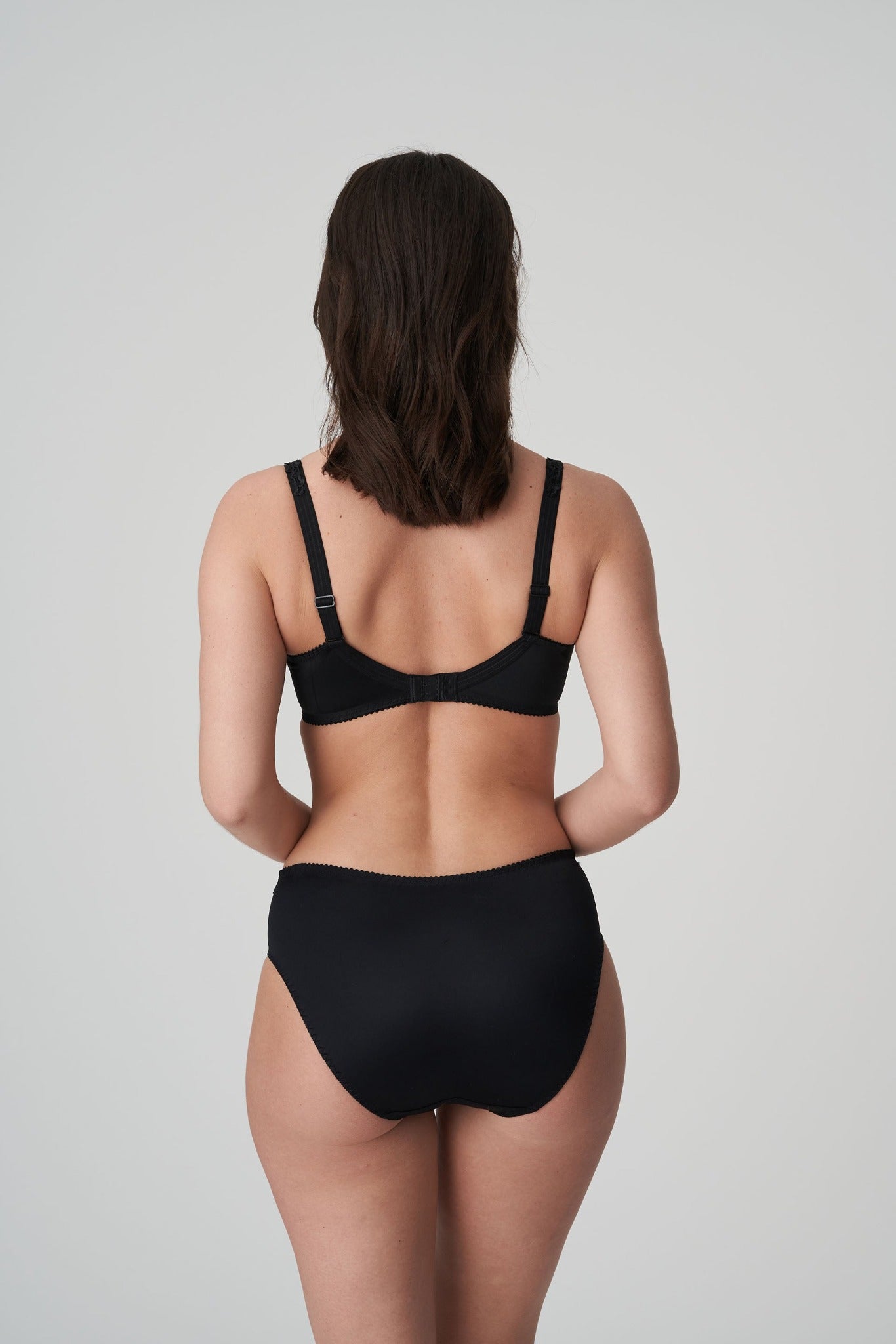Back view of a woman wearing the Deauville full cup bra paired with the Deauville high-waisted full brief in Black by Primadonna.