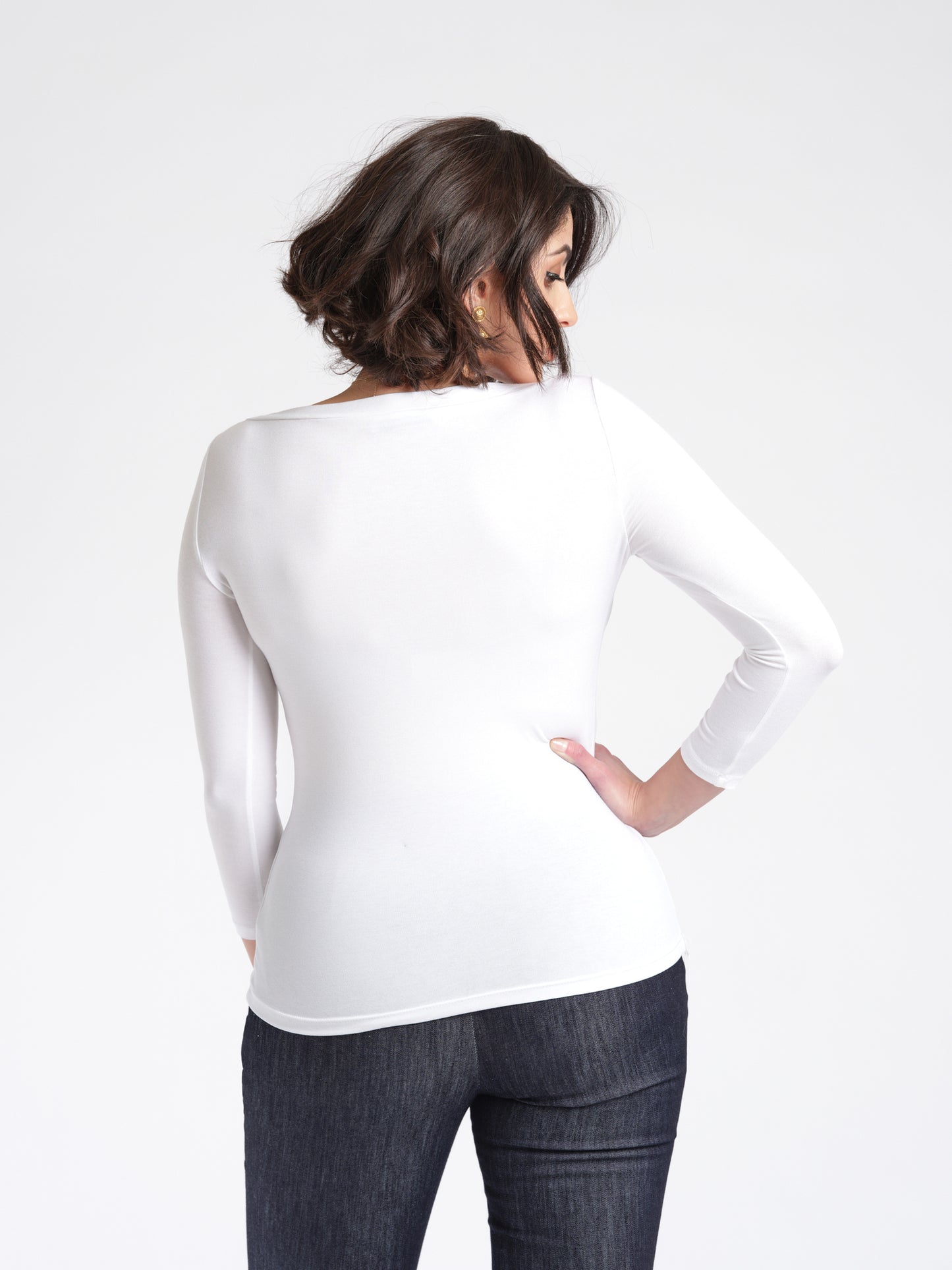 Back view of a woman wearing a white 3/4 length sleeve fuller bust bamboo pullover with stylized boatneck by Miriam Baker.
