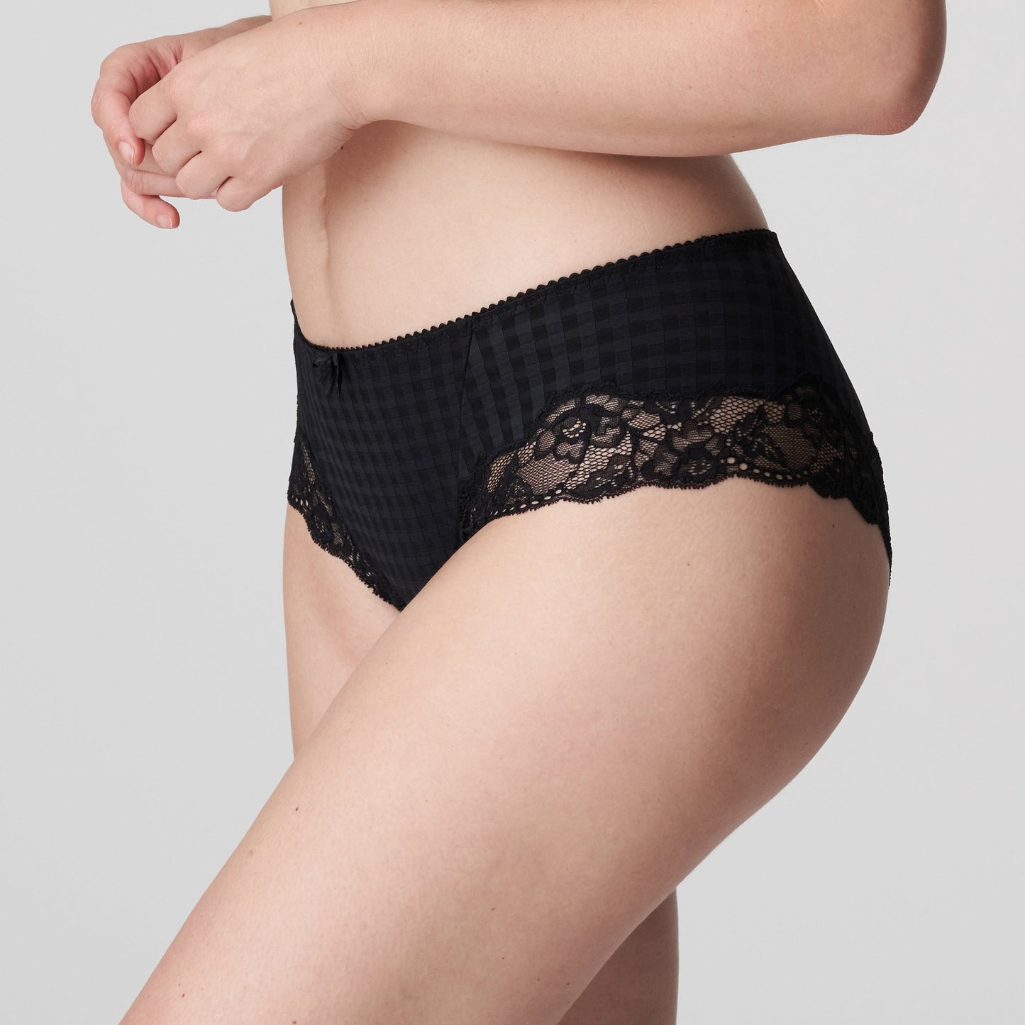 Side view of a woman wearing the Madison cheeky cut panty with lace inserts in Black by Primadonna.