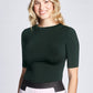 Woman wearing a fitted viscose crew neck fuller bust half sleeve T-shirt, tucked in front view of the Aarti Shirt in Bottle Green by Miriam Baker.