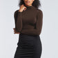Woman wearing a brown stretch viscose fuller bust long sleeve mock neck pullover by Miriam Baker.